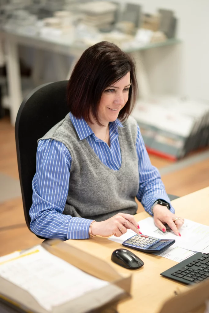 Mathilde du bureau étude effectuant un calcul à l'aide d'une calculatrice